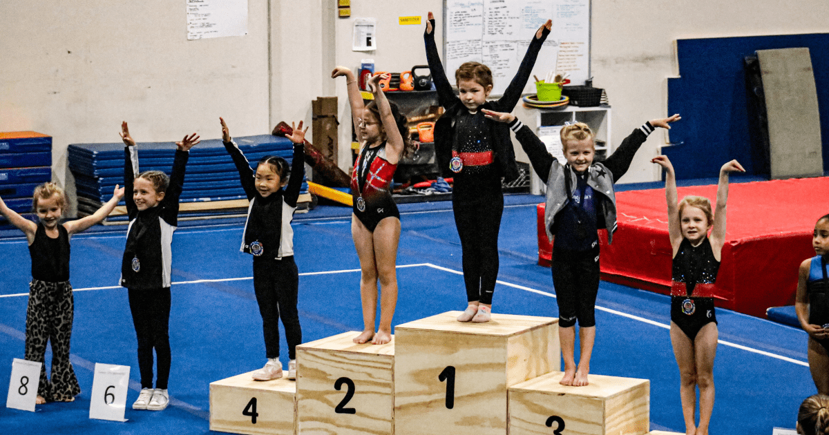 After gymnastic classes a young gymnasts celebrating on the awards podium after a FlipZone gymnastics competition in Lee’s Summit, MO