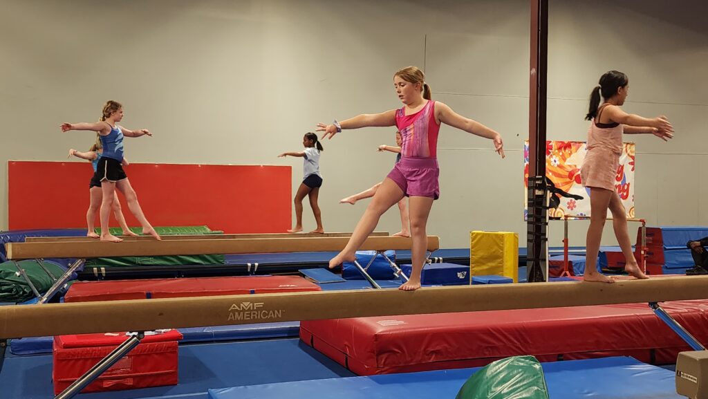 Kids practicing balance beam gymnastics at FlipZone in Lee’s Summit to build coordination, confidence, and strength